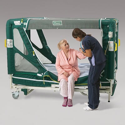 Nurse helping elderly lady out of a Posey Enclosure Bed made by TIDI Products