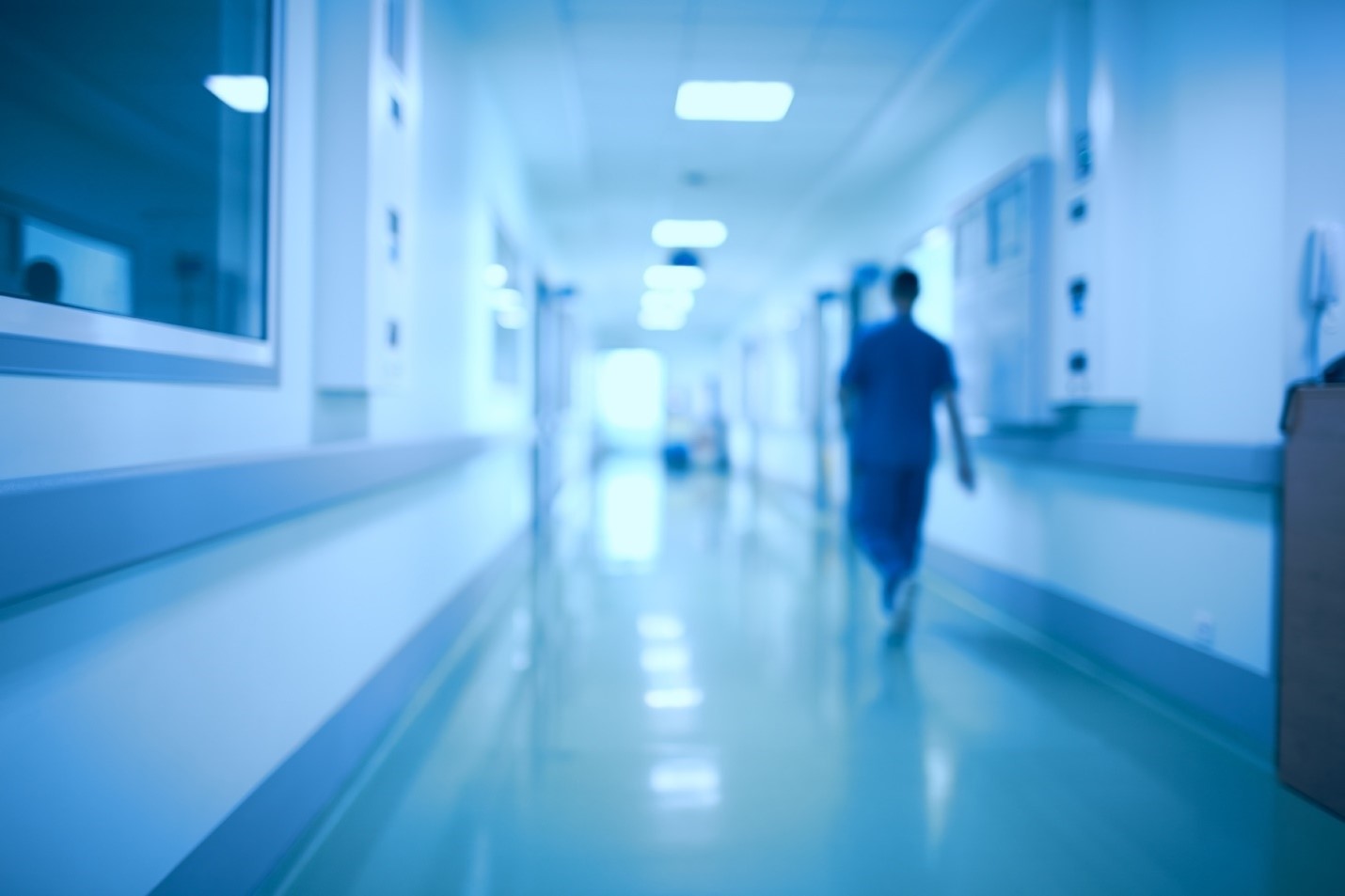 nurse walking down hospital hallway 