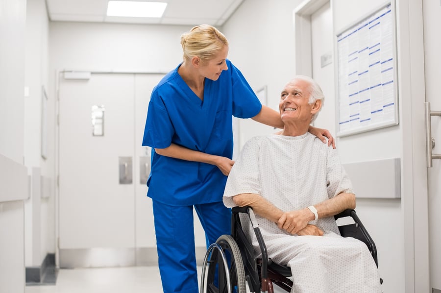 Hospital nurse pushing patient in a wheelchair equipped with TID Products' Headstart Chair Exit Sensor that helps assist care givers with hospital falls prevention