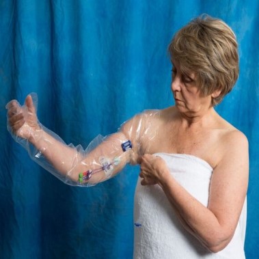 Woman wearing an AquaGuard Arm Shower Sleeve Glove with reusable locking water seal band.