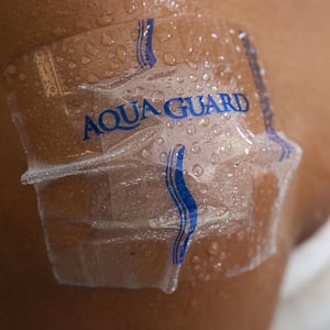 AquaGuard 4x4 Shower Cover over on a person's shoulder in the shower.