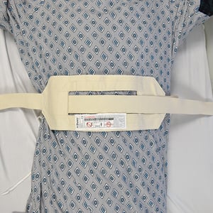 man in bed with a restraint roll belt