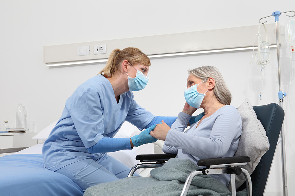nurse-with-patient-sitting-in-chair-istock-1257353467
