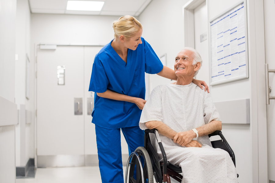 tidi-stock-nurse-pushing-man-in-wheelchair-hospital-hallway