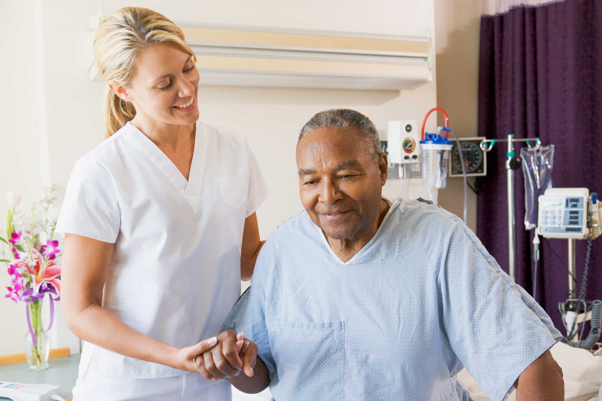 nurse_smiling_helping_patient_out_of_bed