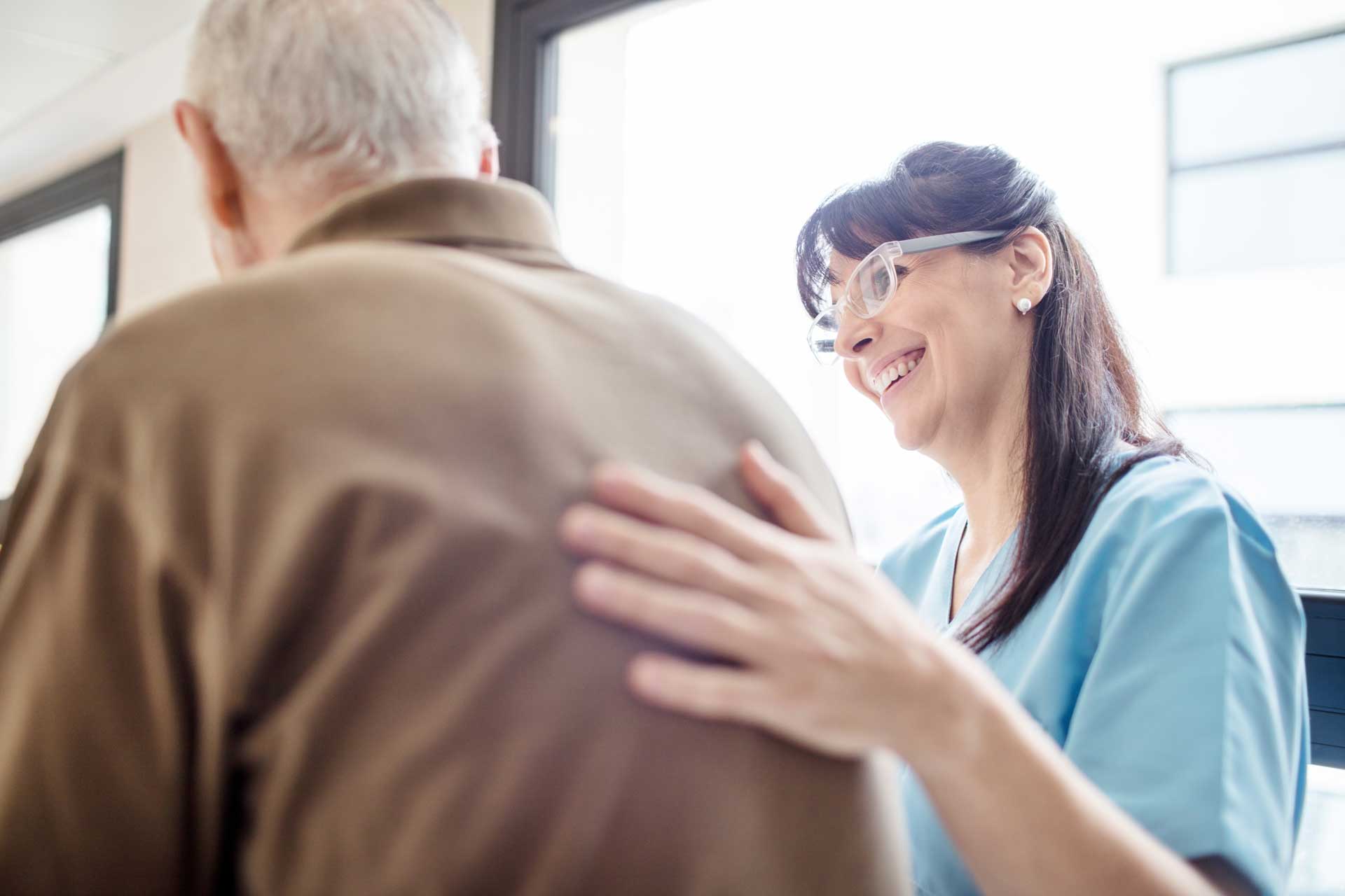 nurse_smiling_with_hand_on_patients_back