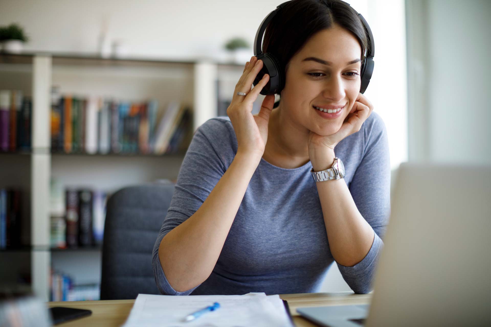 woman_with_headphones_smiling_watching_laptop